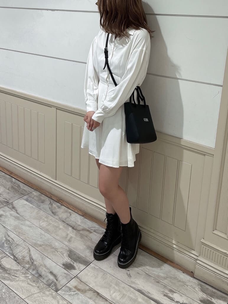 ホワイト系のワンピース、ブラック系のブーツ、ブラック系のショルダーバッグを着用したレディースの秋コーディネートの4枚目の写真