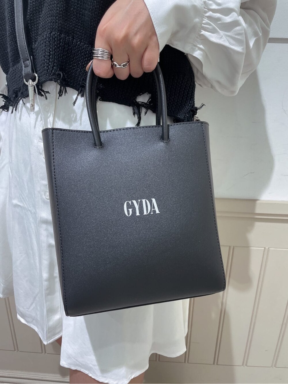 ホワイト系のワンピース、ブラック系のブーツ、ブラック系のショルダーバッグを着用したレディースの秋コーディネートの7枚目の写真