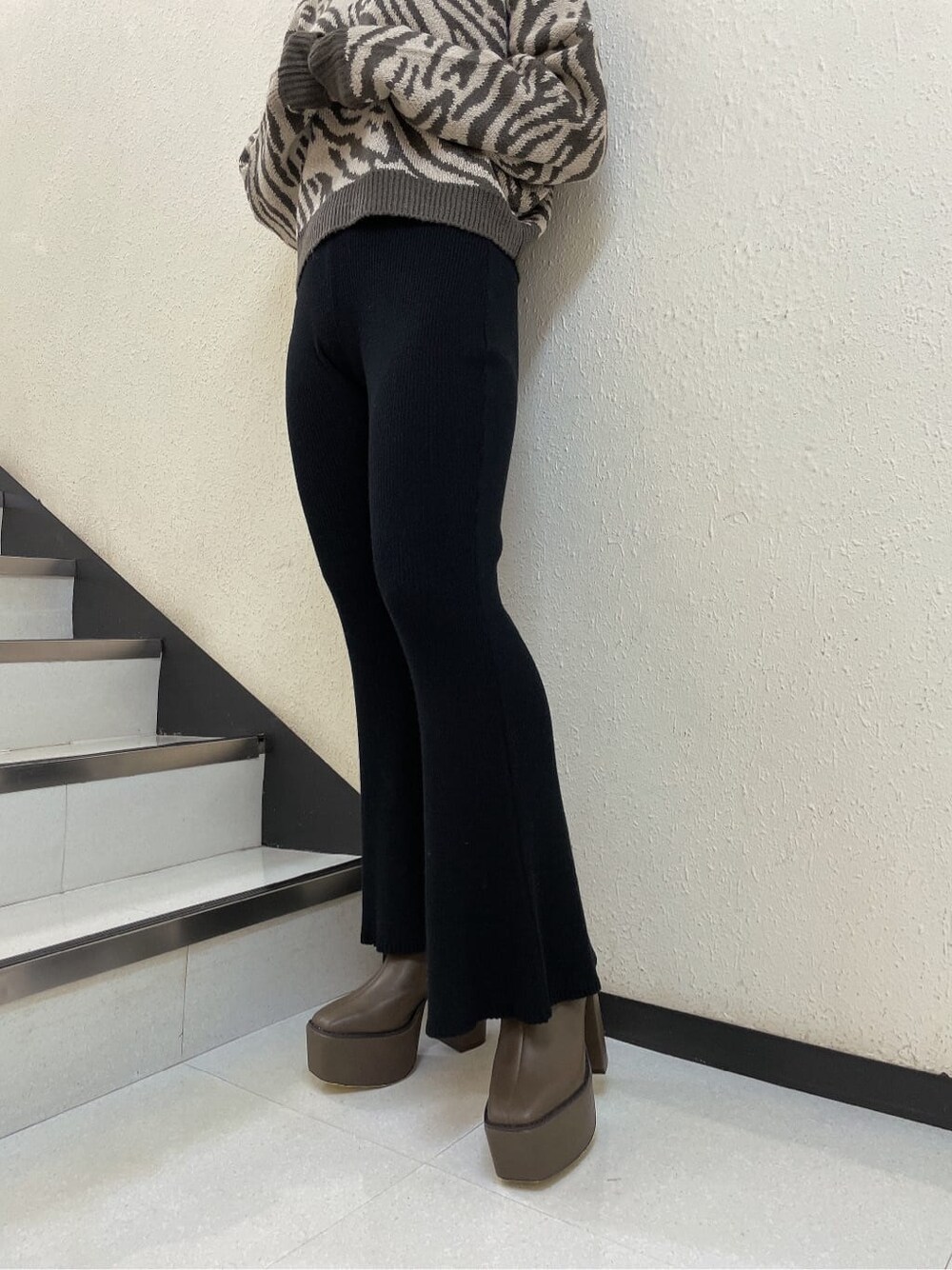 ベージュ系のブーツ、ブラック系のその他パンツ、ベージュ系のニット/セーターを着用したレディースの秋コーディネートの5枚目の写真