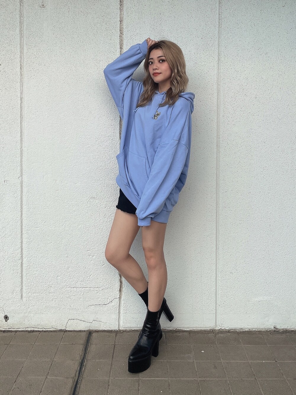 ブルー系のパーカー、ブラック系のブーツを着用したレディースの秋コーディネートの3枚目の写真