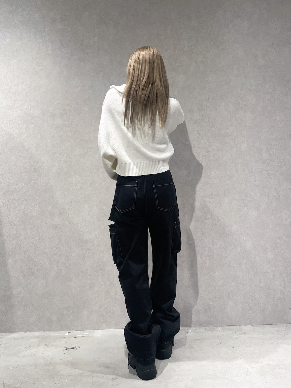 ホワイト系のニット/セーター、ブラック系のカーゴパンツ、ブラック系のブーツを着用したレディースの秋コーディネートの2枚目の写真