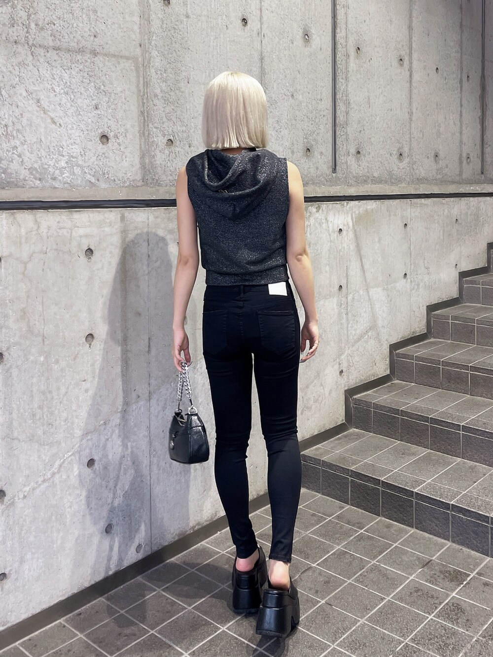 ブラック系のTシャツ/カットソー、ブラック系のデニムパンツ、ブラック系のサンダルを着用したレディースの夏コーディネートの2枚目の写真
