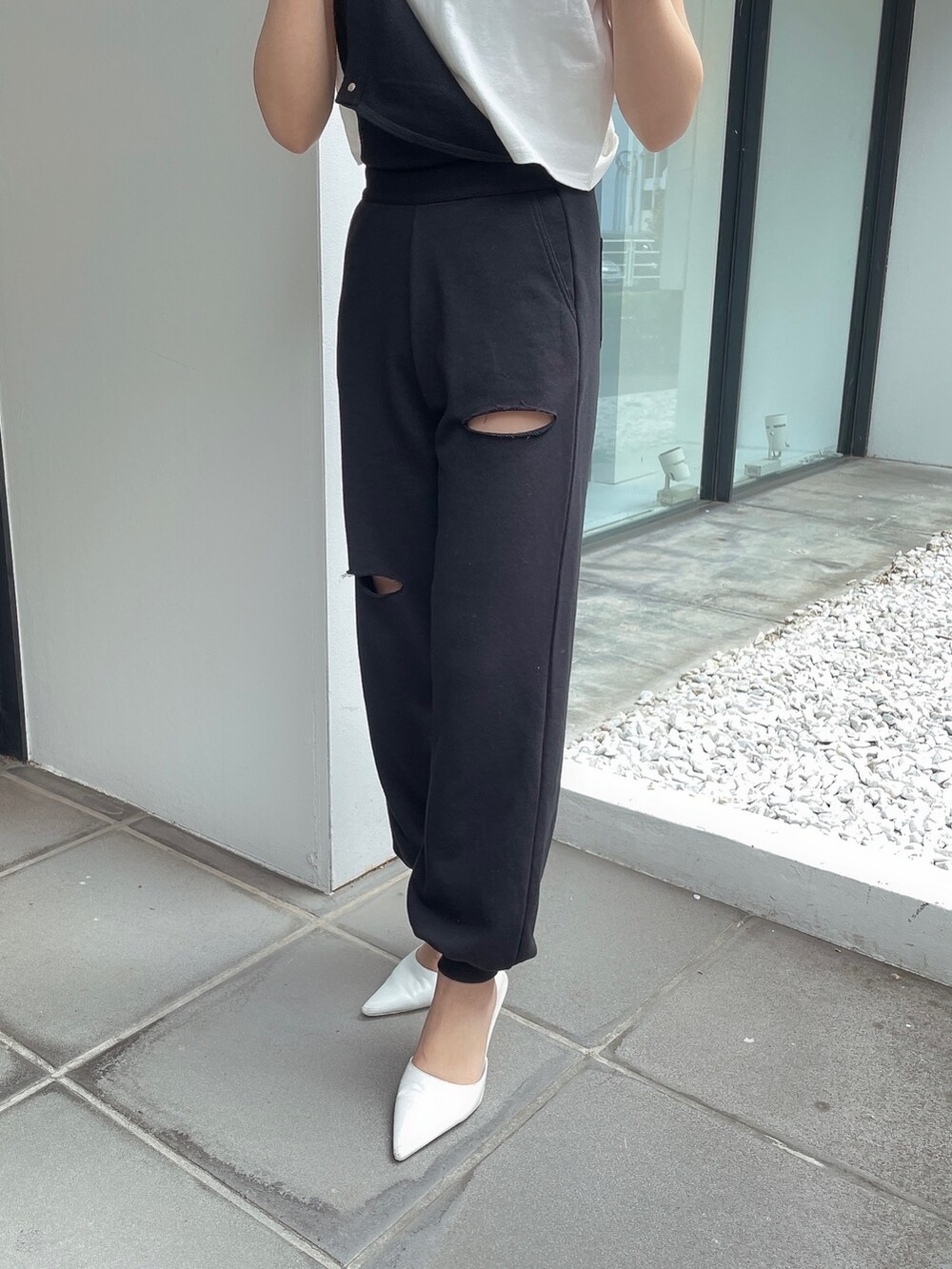 ブラック系のつなぎ/オールインワン、ホワイト系のTシャツ/カットソー、ホワイト系のパンプスを着用したレディースの春コーディネートの5枚目の写真