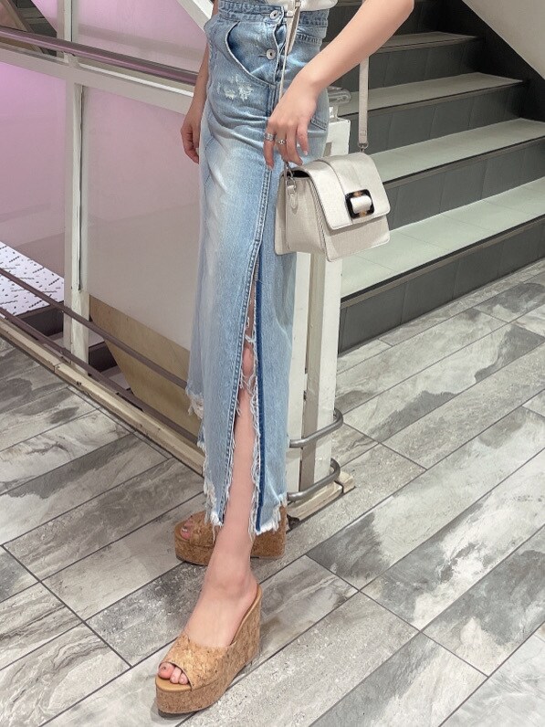 ブルー系のジャンパースカート、ベージュ系のサンダル、ホワイト系のニット/セーターを着用したレディースの春コーディネートの6枚目の写真