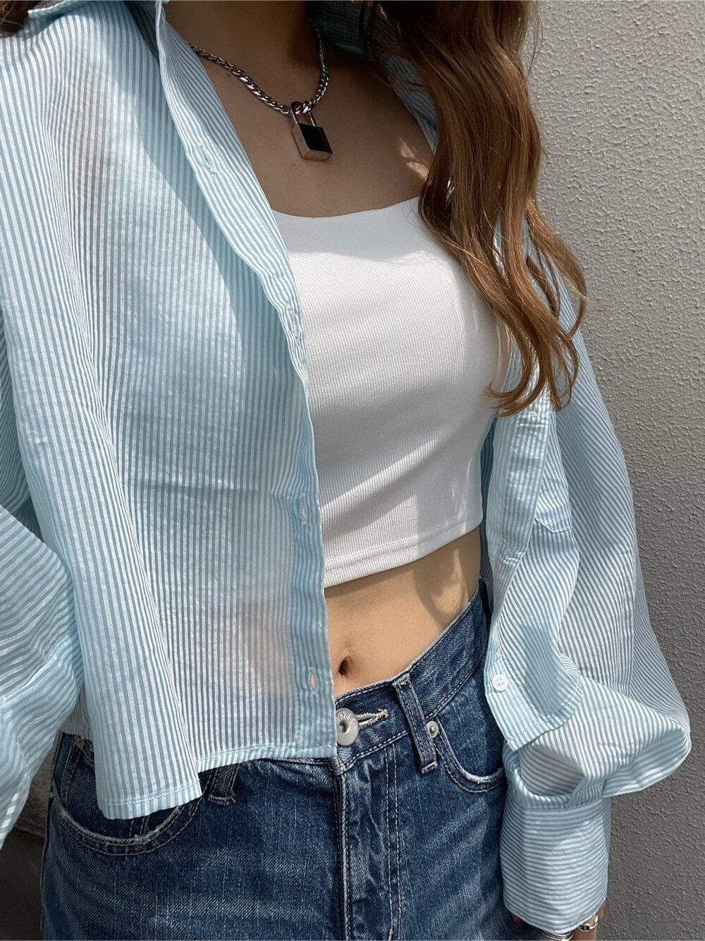 ホワイト系のパンプス、ホワイト系のキャミソール、ブルー系のデニムパンツを着用したレディースの春コーディネートの5枚目の写真