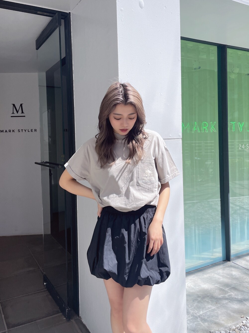 ベージュ系のTシャツ/カットソー、ブラック系のスカート、ブラック系のサンダルを着用したレディースの春コーディネートの4枚目の写真