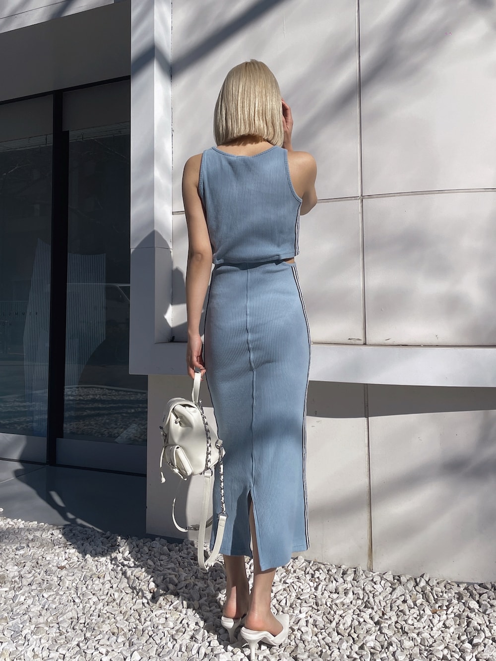 ブルー系のワンピース、ホワイト系のパンプス、ホワイト系のバックパック/リュックを着用したレディースの春コーディネートの3枚目の写真