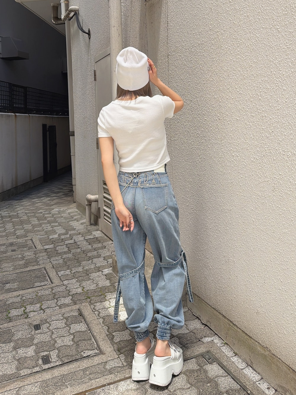 ホワイト系のTシャツ/カットソー、ブルー系のデニムパンツ、ホワイト系のサンダルを着用したレディースの春コーディネートの4枚目の写真
