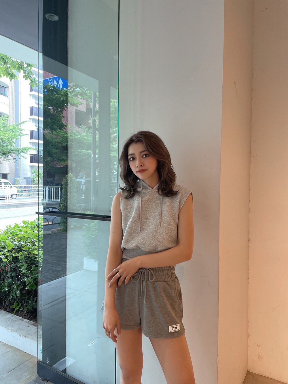 グレー系のパーカー、グレー系のスウェットパンツ、ホワイト系のスニーカーを着用したレディースの夏コーディネートの4枚目の写真