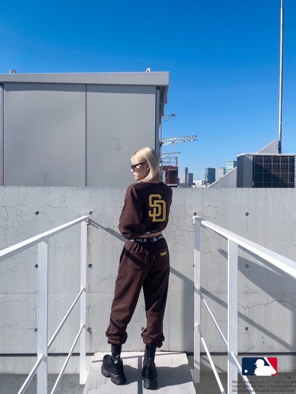 ブラック系のブーツ、ブラウン系のスウェットパンツ、ブラウン系のスウェットを着用したレディースの冬コーディネートの3枚目の写真