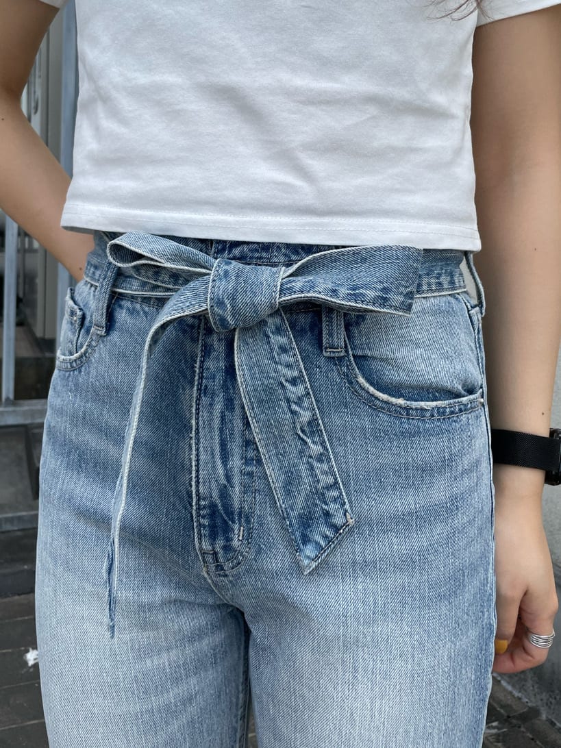 ホワイト系のサンダル、ホワイト系のTシャツ/カットソー、ブルー系のデニムパンツを着用したレディースの春コーディネートの6枚目の写真