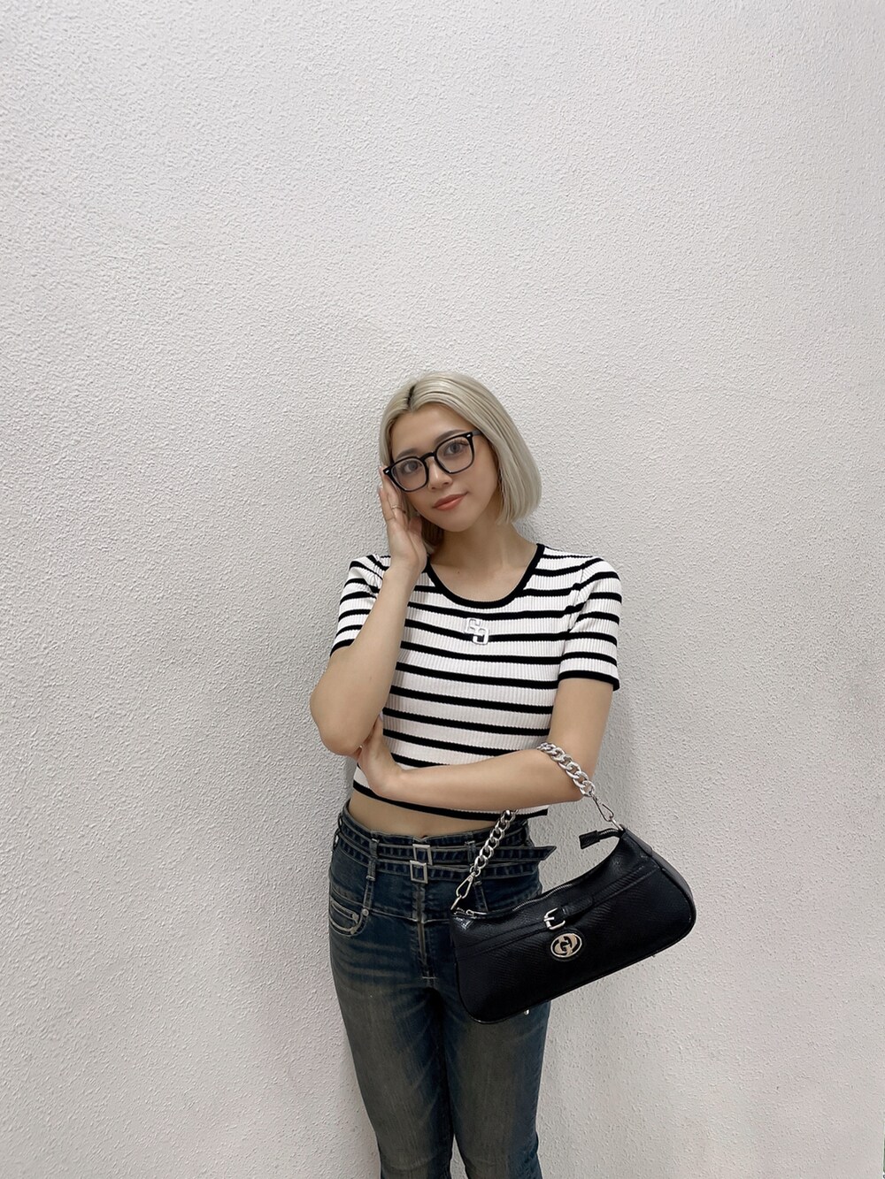 その他のニット/セーター、ブルー系のデニムパンツ、ブラック系のハンドバッグを着用したレディースの夏コーディネートの3枚目の写真