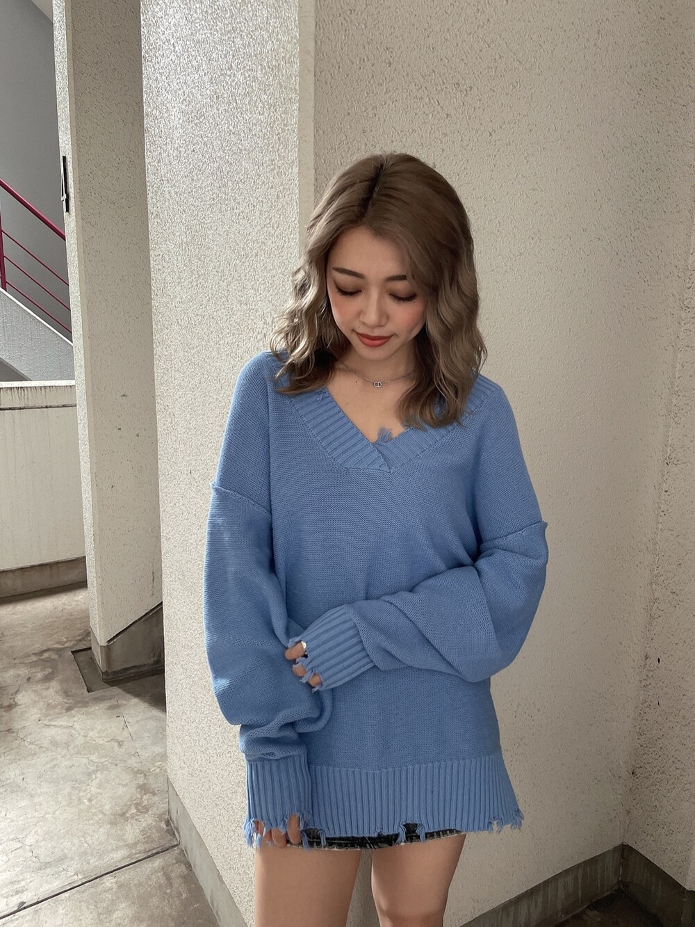 ブルー系のニット/セーター、ブラック系のブーツを着用したレディースの秋コーディネートの6枚目の写真