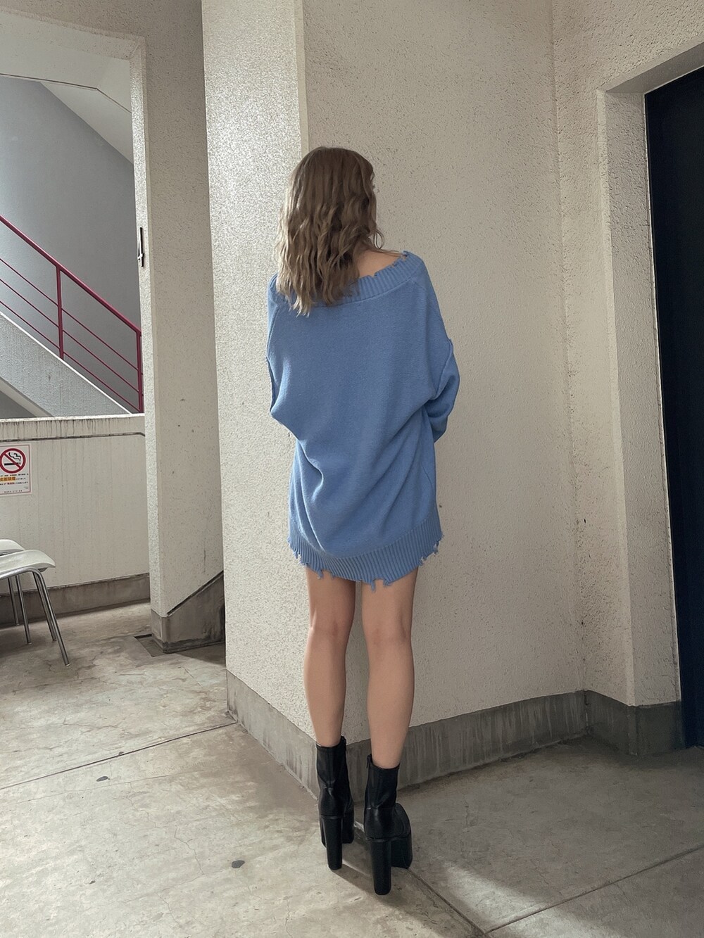 ブルー系のニット/セーター、ブラック系のブーツを着用したレディースの秋コーディネートの3枚目の写真