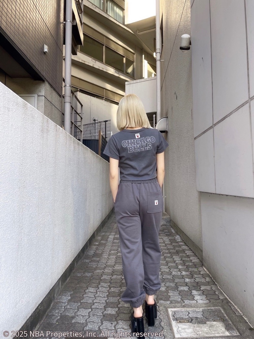 グレー系のTシャツ/カットソー、グレー系のスウェットパンツ、ブラック系のサンダルを着用したレディースの夏コーディネートの2枚目の写真