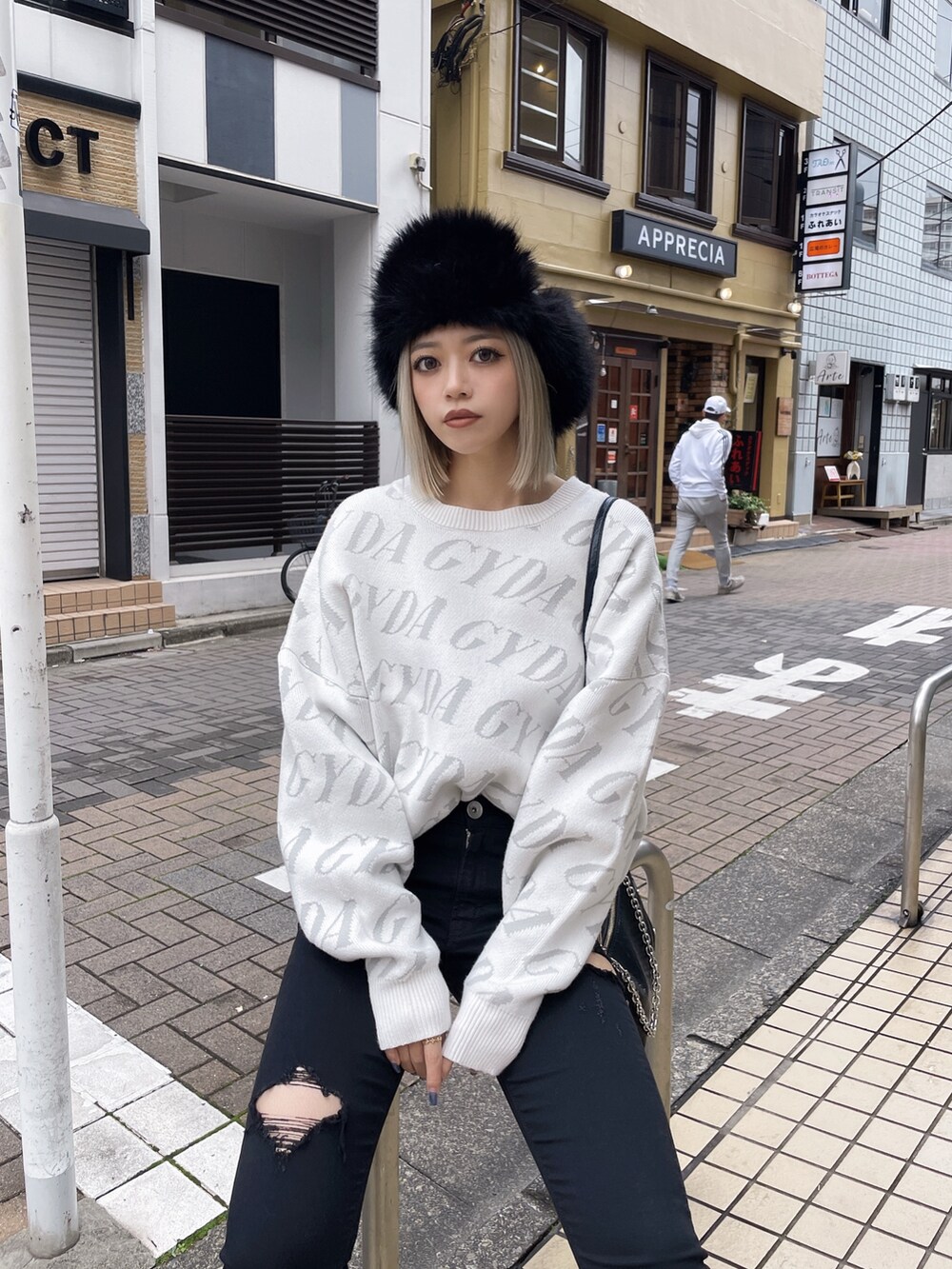 ホワイト系のニット/セーター、ブラック系のデニムパンツ、ブラック系のブーツを着用したレディースの秋コーディネートの2枚目の写真