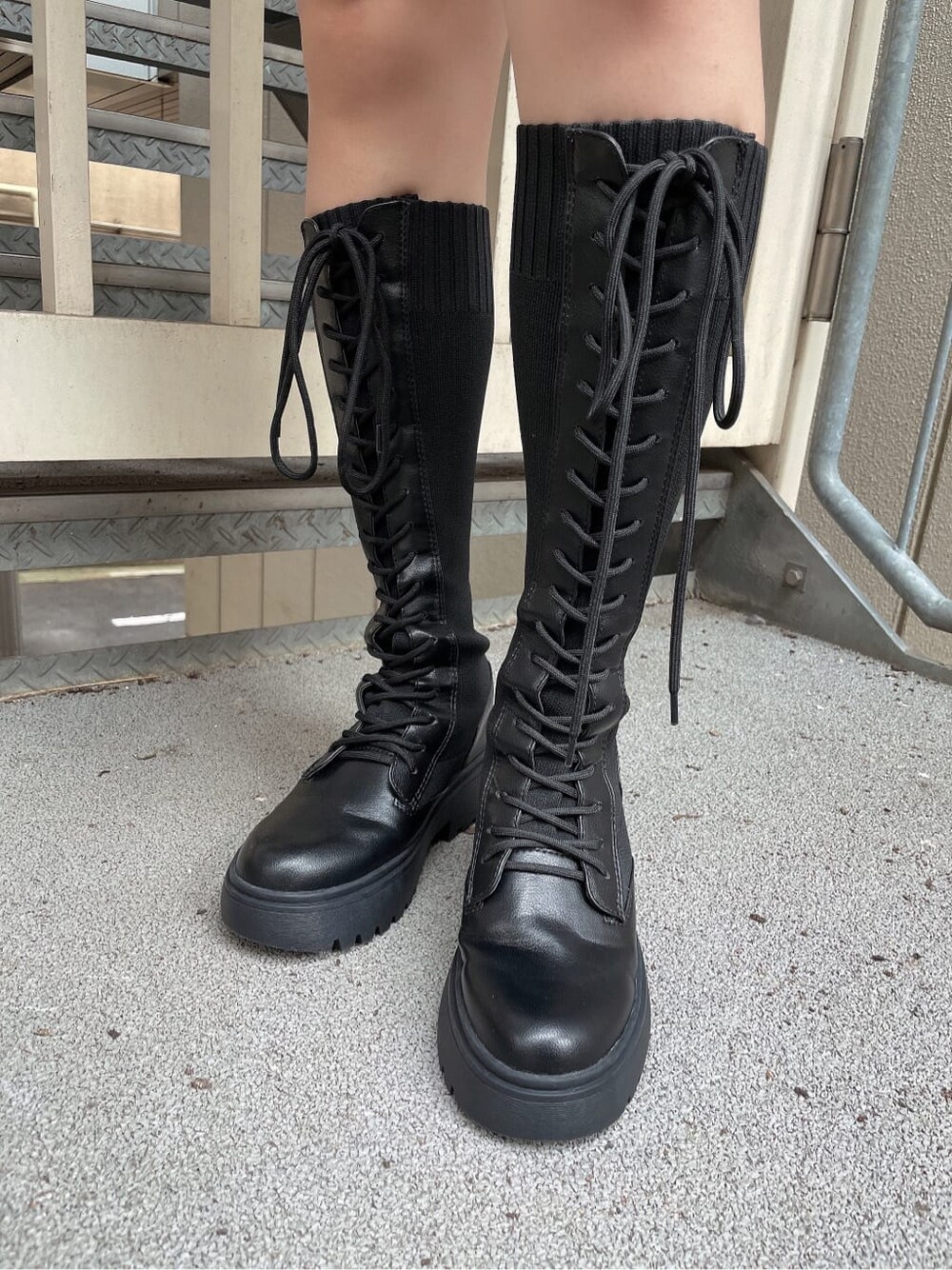 ベージュ系のMA-1、ブラック系のワンピース、ブラック系のブーツを着用したレディースの秋コーディネートの5枚目の写真