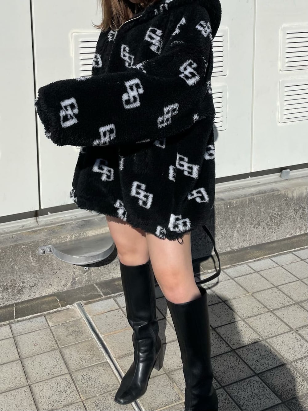 ブラック系のニット/セーター、ブラック系のブーツ、ブラック系のスカートを着用したレディースの秋コーディネートの4枚目の写真