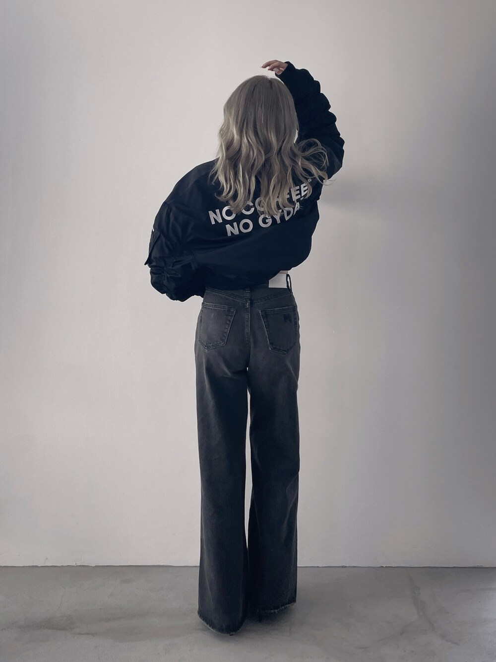 ブラック系のブルゾン、ブラック系のキャミソール、ブラック系のデニムパンツを着用したレディースの秋コーディネートの2枚目の写真