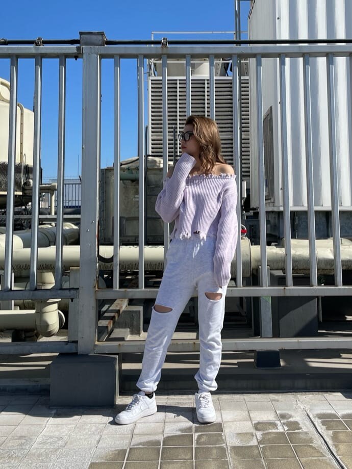 パープル系のニット/セーター、ホワイト系のパンプス、グレー系のその他パンツを着用したレディースの冬コーディネートの3枚目の写真