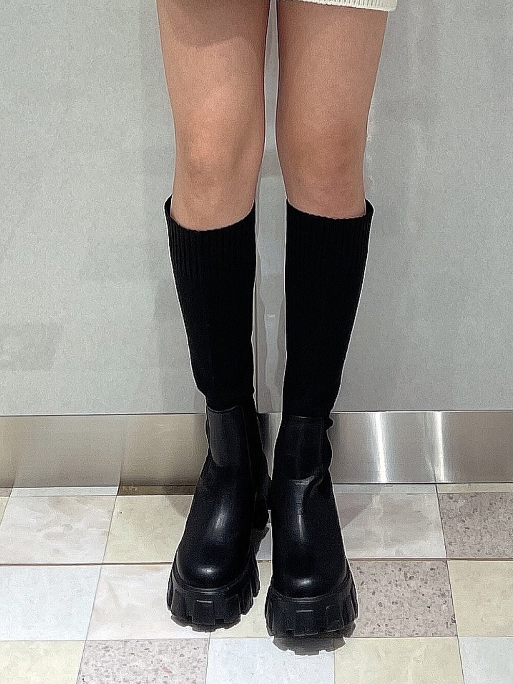 ホワイト系のニット/セーター、ブラック系のブーツを着用したレディースの秋コーディネートの6枚目の写真