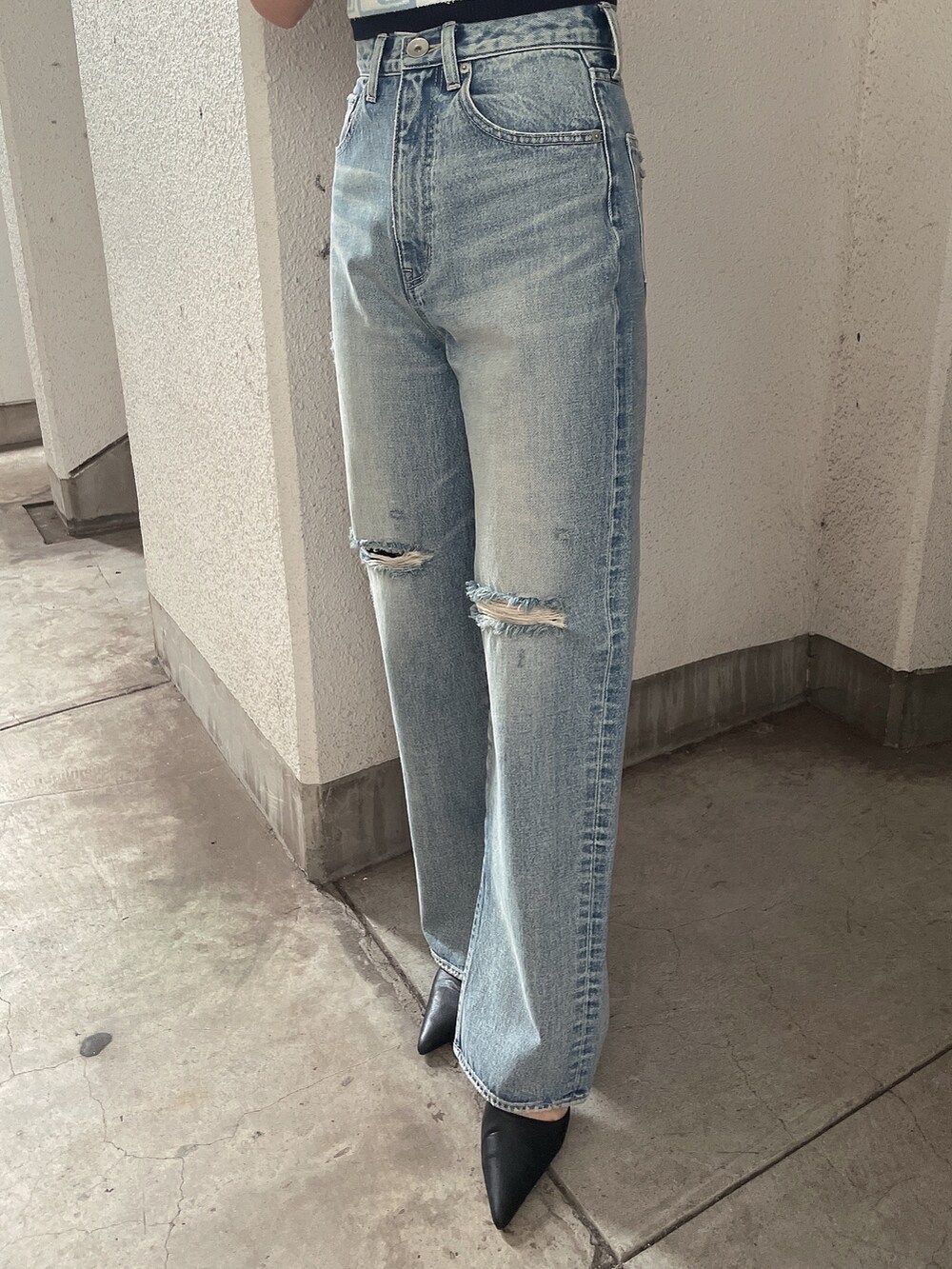 ブルー系のニット/セーター、ブルー系のデニムパンツ、ブラック系のパンプスを着用したレディースの冬コーディネートの7枚目の写真