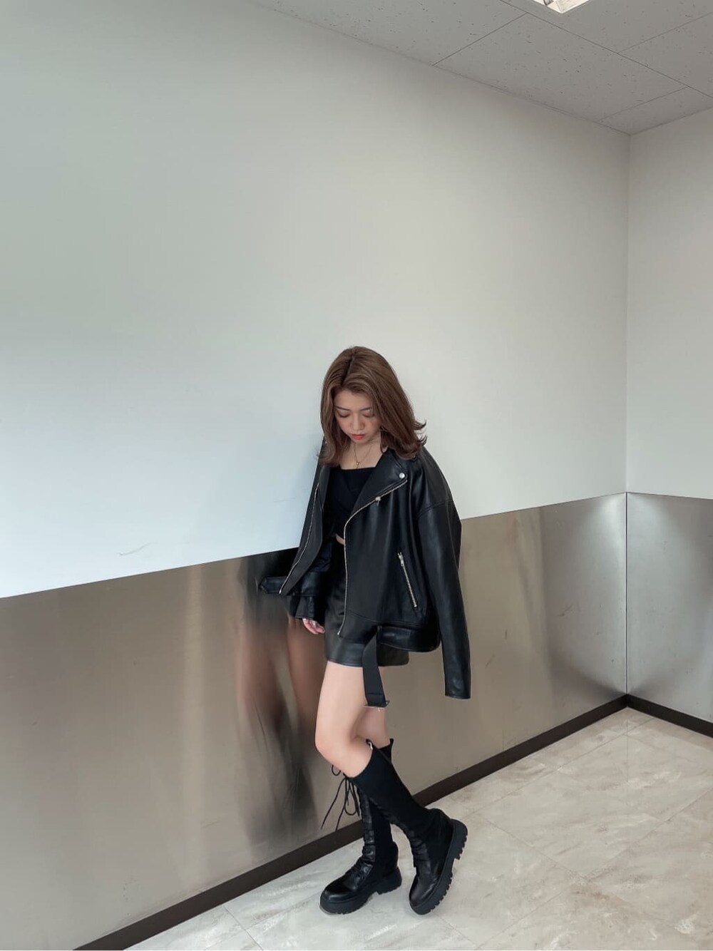 ブラック系のブーツ、ブラック系のTシャツ/カットソー、ブラック系のライダースジャケットを着用したレディースの秋コーディネートの4枚目の写真