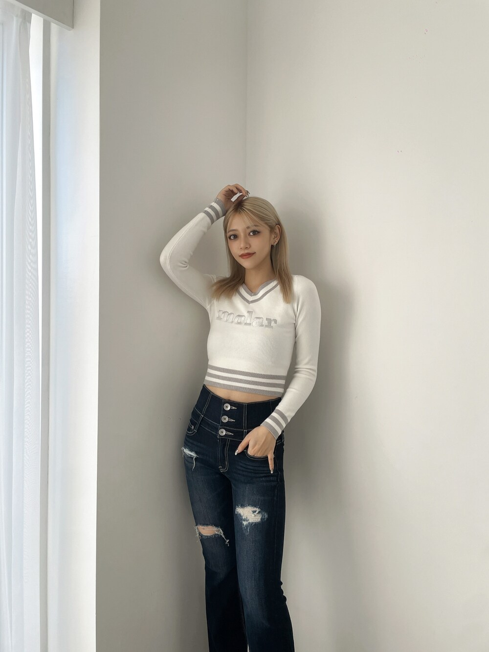 ホワイト系のニット/セーター、ブルー系のデニムパンツ、ブラック系のブーツを着用したレディースの冬コーディネートの4枚目の写真