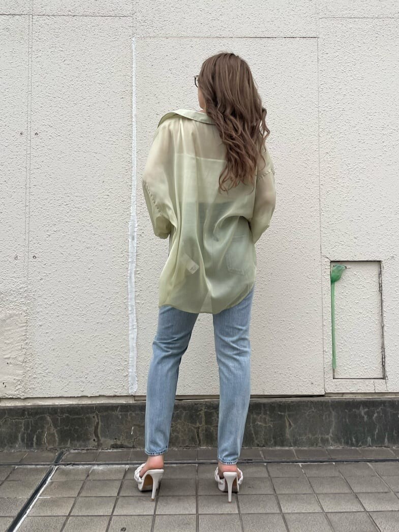 イエロー系のシャツ/ブラウス、ホワイト系のサンダル、ブルー系のデニムパンツを着用したレディースの春コーディネートの2枚目の写真