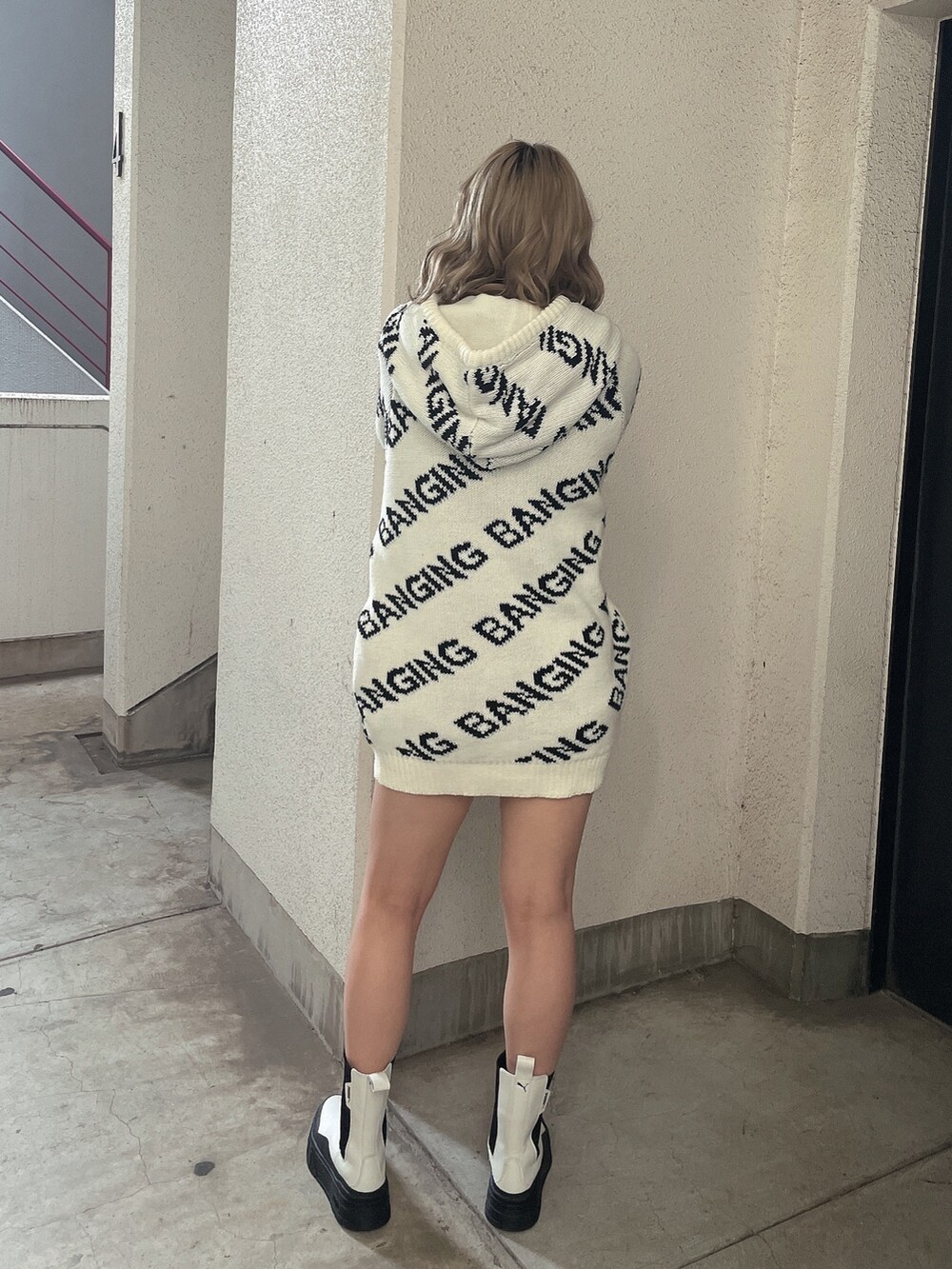 ホワイト系のニット/セーター、ホワイト系のブーツを着用したレディースの冬コーディネートの3枚目の写真