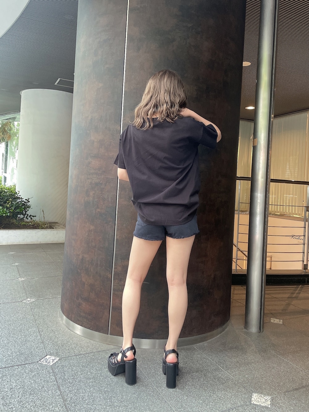 ブラック系のデニムパンツ、ブラック系のサンダル、ブラック系のTシャツ/カットソーを着用したレディースの夏コーディネートの3枚目の写真