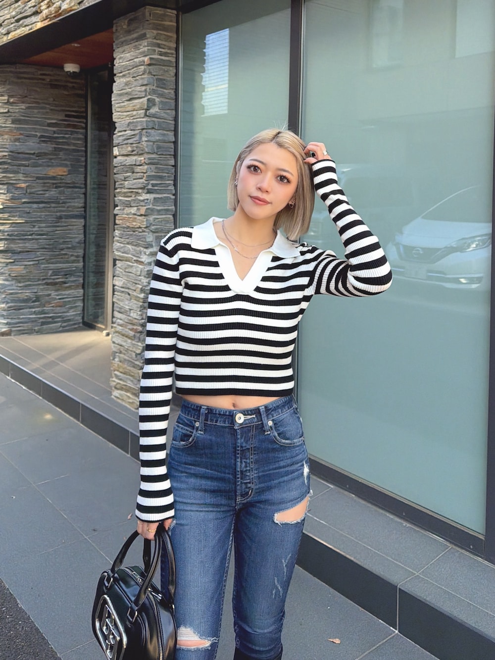 その他のニット/セーター、ブラック系のハンドバッグ、ブラック系のブーツを着用したレディースの冬コーディネートの4枚目の写真