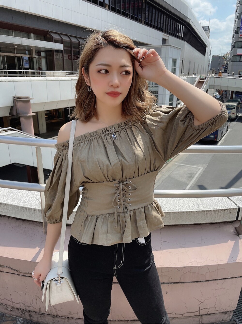 ブラック系のデニムパンツ、ベージュ系のシャツ/ブラウス、ベージュ系のサンダルを着用したレディースの春コーディネートの3枚目の写真