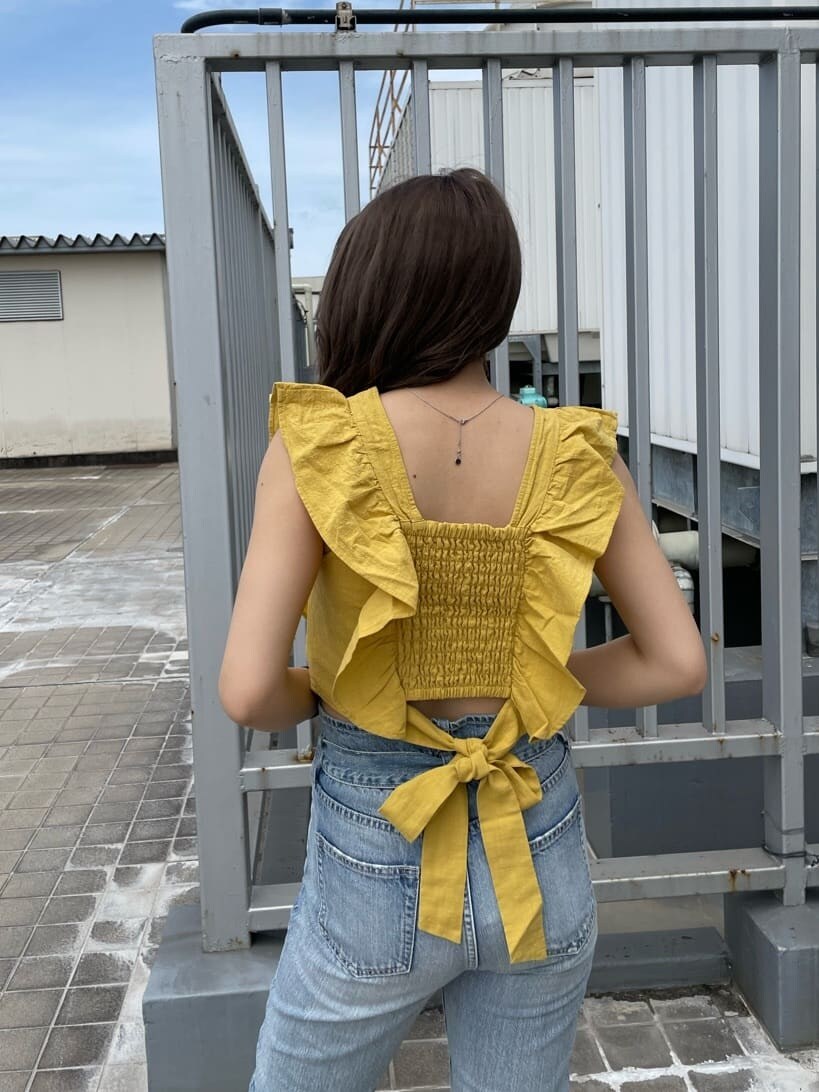 イエロー系のシャツ/ブラウス、ホワイト系のサンダル、ブルー系のデニムパンツを着用したレディースの春コーディネートの4枚目の写真