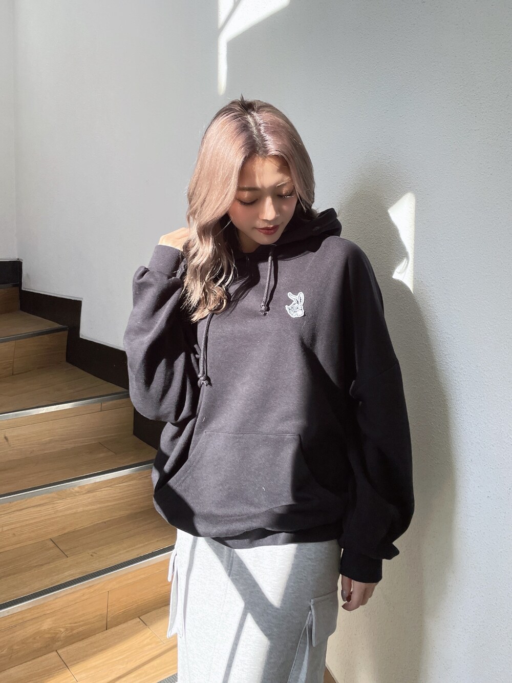 ブラック系のパーカー、グレー系のスカート、ブラック系のスニーカーを着用したレディースの冬コーディネートの4枚目の写真