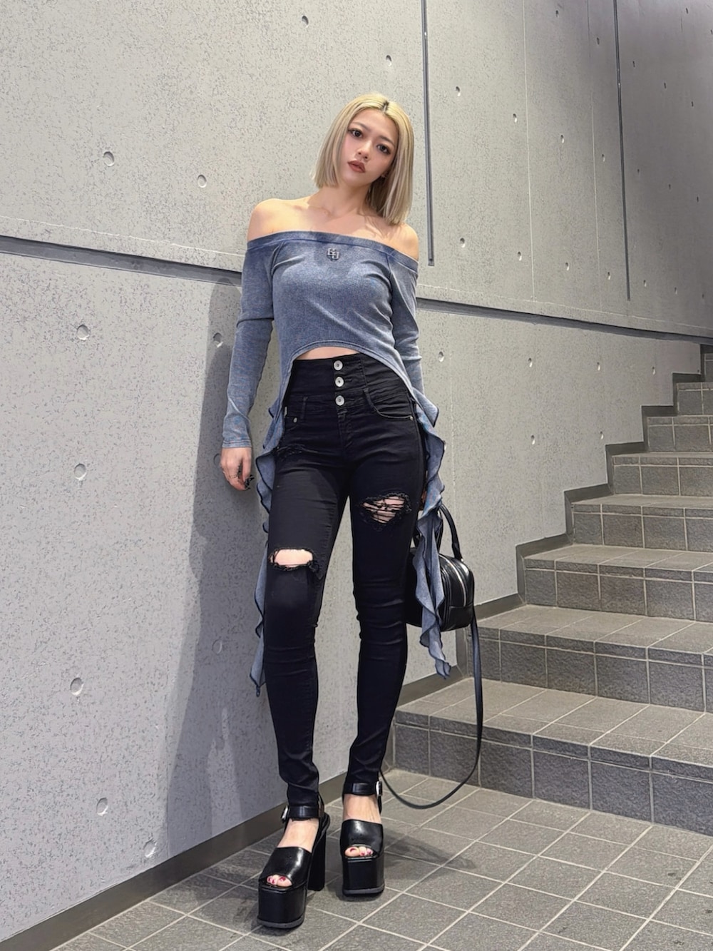 ブルー系のTシャツ/カットソー、ブラック系のハンドバッグ、ブラック系のデニムパンツを着用したレディースの春コーディネートの4枚目の写真