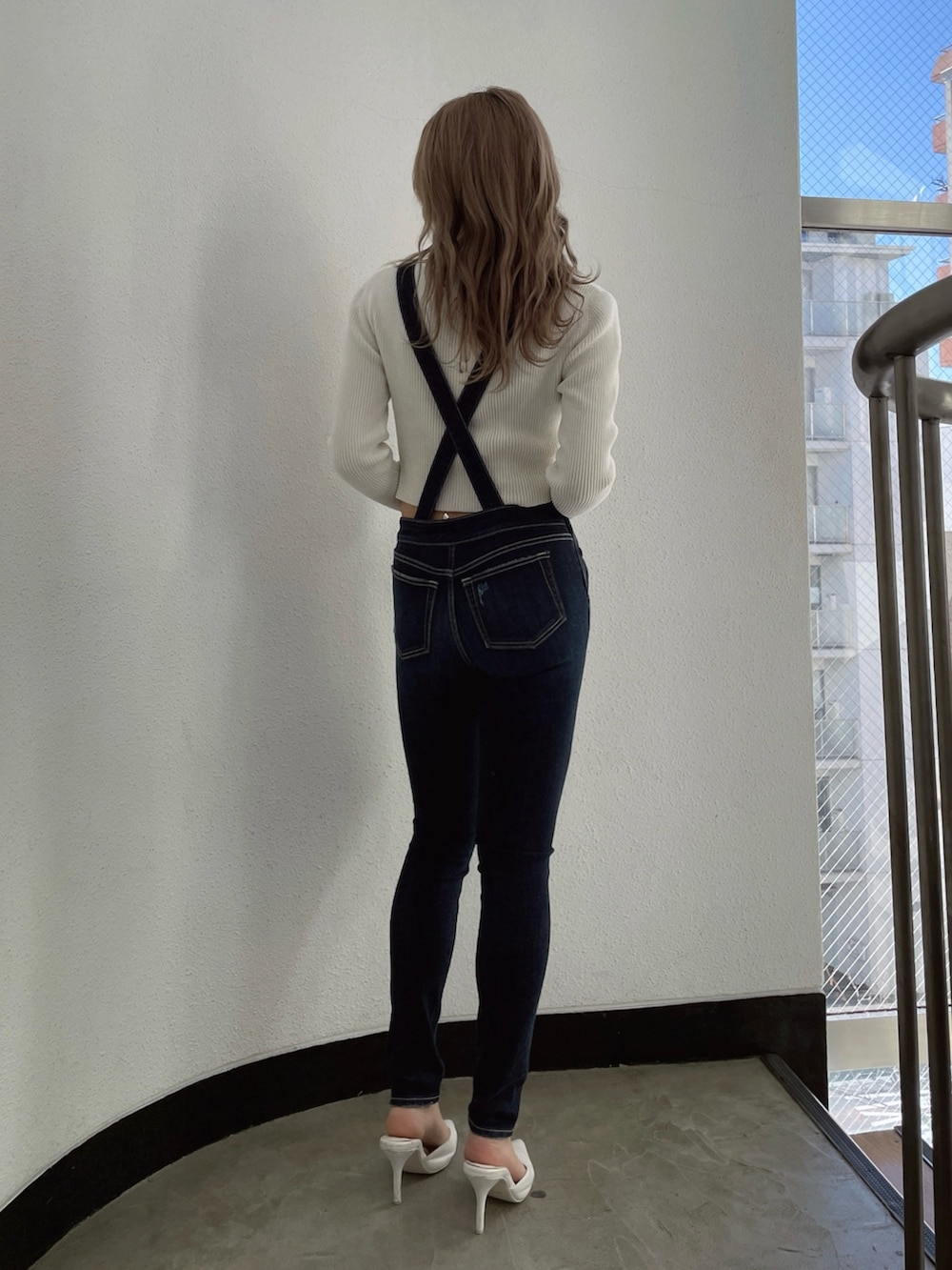 ホワイト系のカーディガン/ボレロ、ブルー系のつなぎ/オールインワン、ホワイト系のパンプスを着用したレディースの冬コーディネートの2枚目の写真
