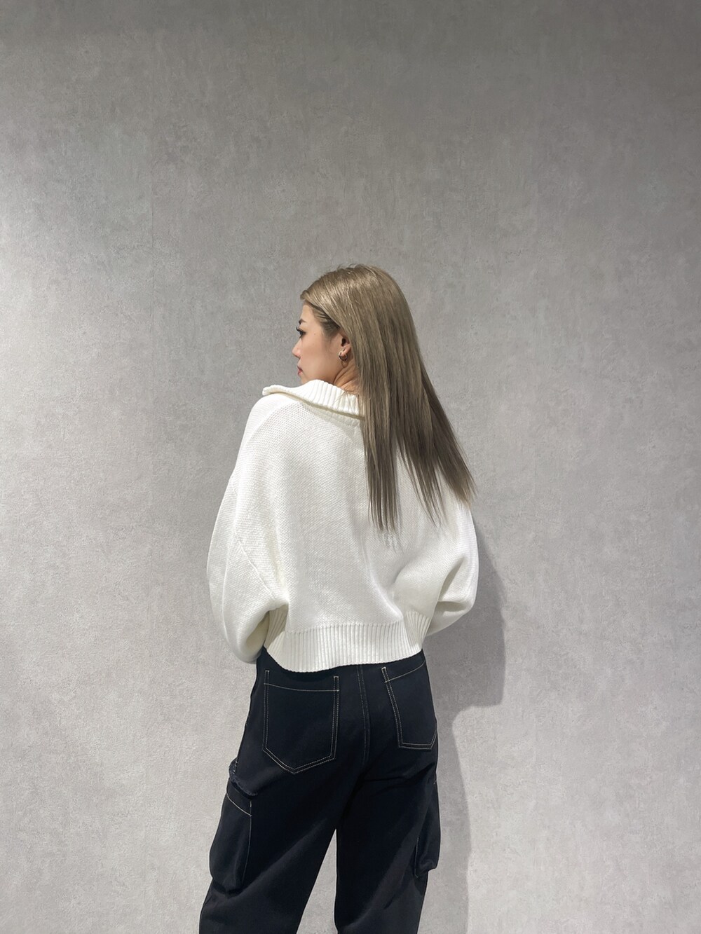 ホワイト系のニット/セーター、ブラック系のカーゴパンツ、ブラック系のブーツを着用したレディースの秋コーディネートの4枚目の写真