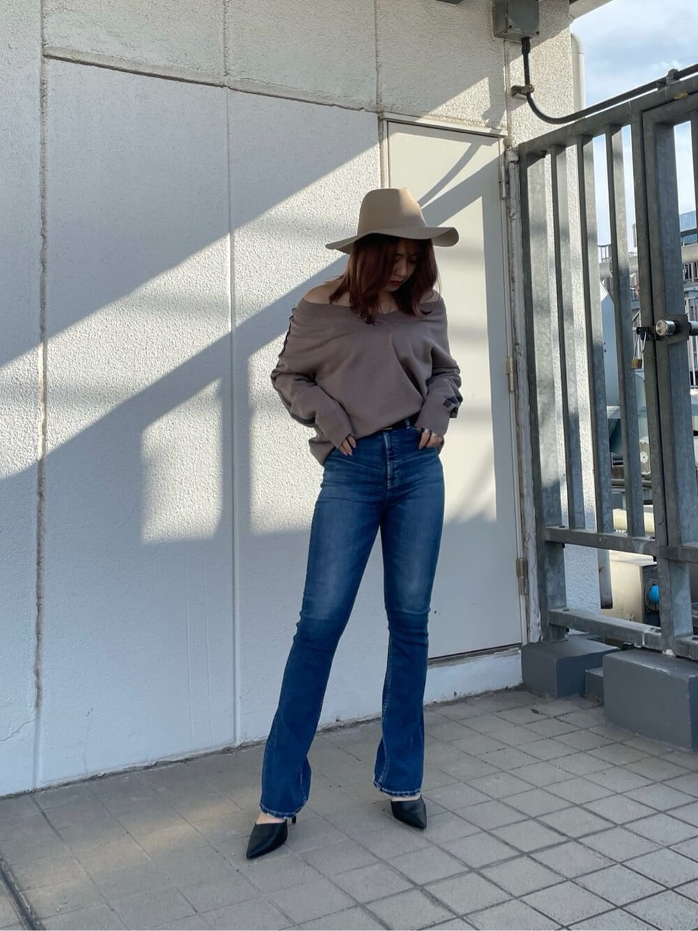 ブラック系のパンプス、ブルー系のデニムパンツ、ベージュ系のニット/セーターを着用したレディースの冬コーディネートの2枚目の写真