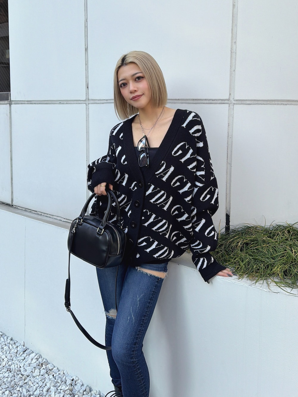 ブラック系のカーディガン/ボレロ、ブルー系のデニムパンツを着用したレディースの冬コーディネートの2枚目の写真