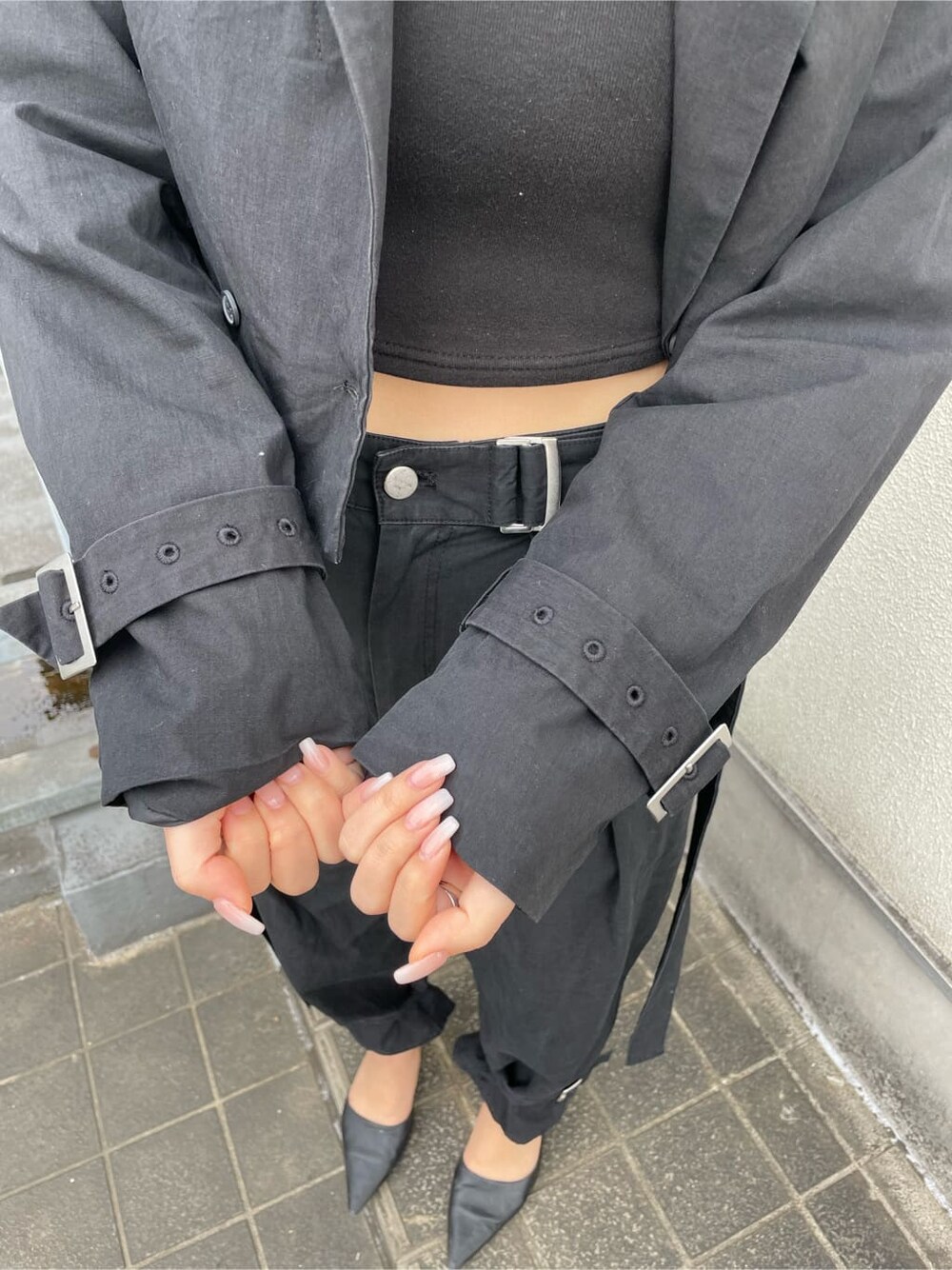 ブラック系のパンプス、ブラック系のスラックス、ブラック系のキャミソールを着用したレディースの春コーディネートの6枚目の写真