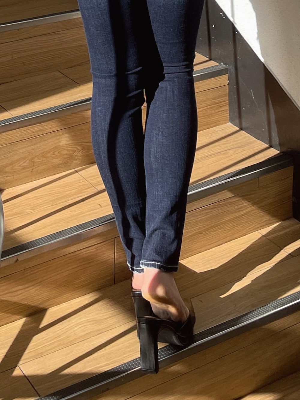 ブラック系のニット/セーター、ブラック系のパンプス、ブルー系のデニムパンツを着用したレディースの冬コーディネートの8枚目の写真