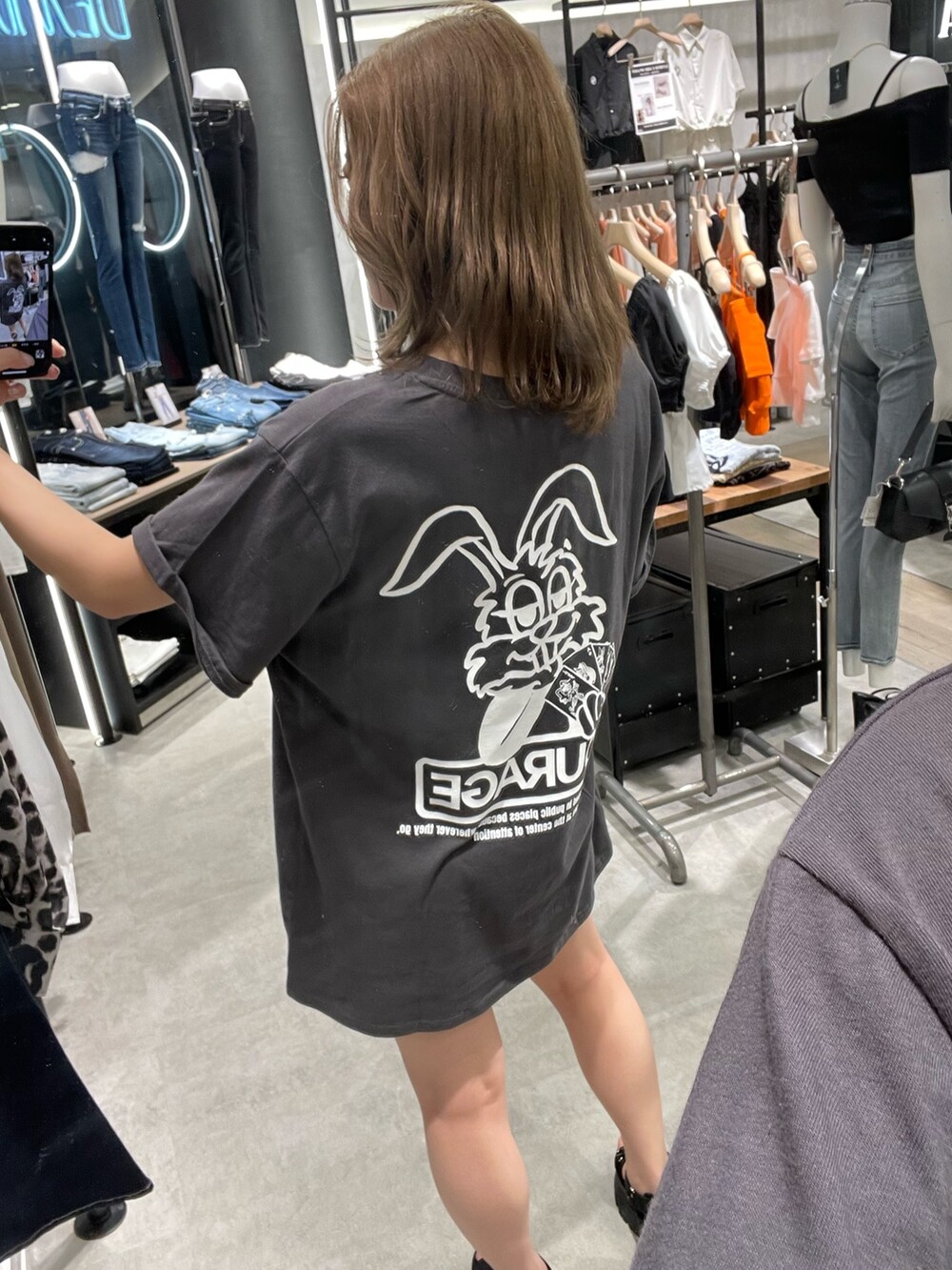 グレー系のTシャツ/カットソー、ブルー系のデニムパンツ、ブラック系のサンダルを着用したレディースの春コーディネートの4枚目の写真