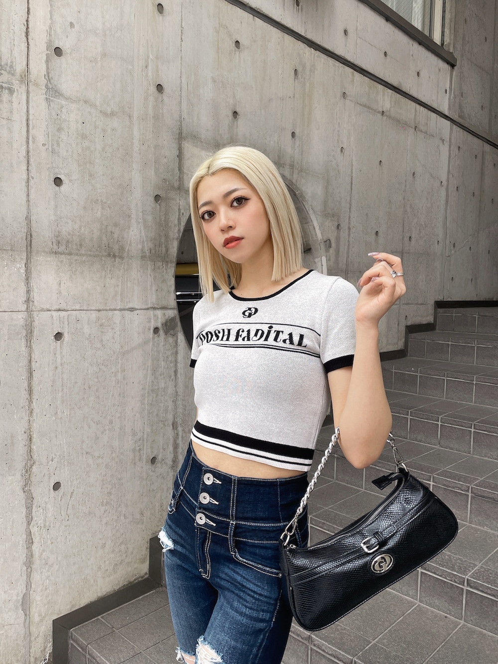 ホワイト系のニット/セーター、ブルー系のデニムパンツ、ブラック系のパンプスを着用したレディースの春コーディネートの4枚目の写真