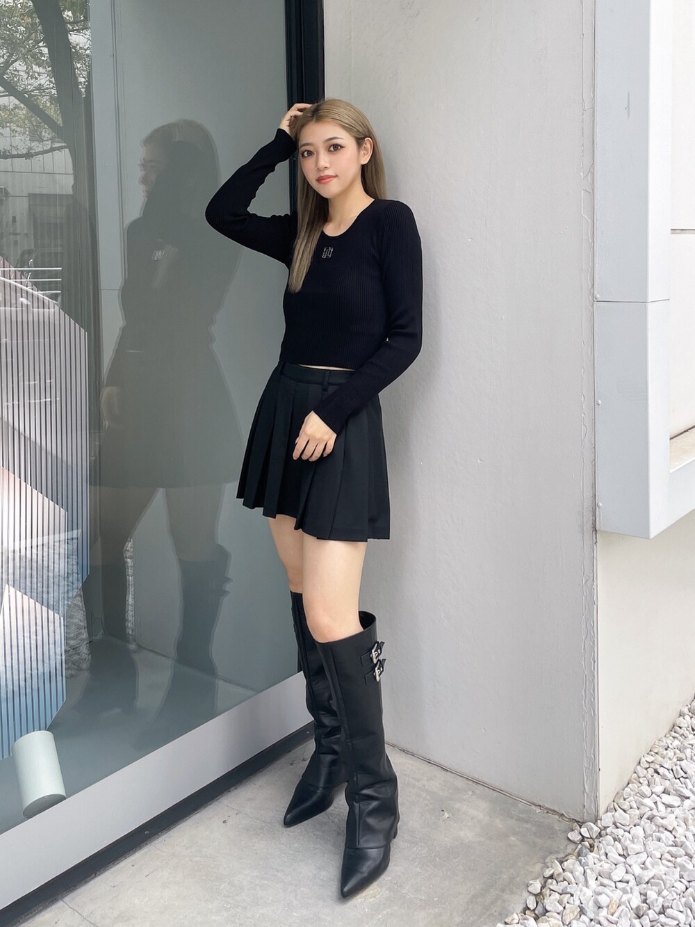 ブラック系のニット/セーター、ブラック系のスカート、ブラック系のブーツを着用したレディースの秋コーディネートの2枚目の写真