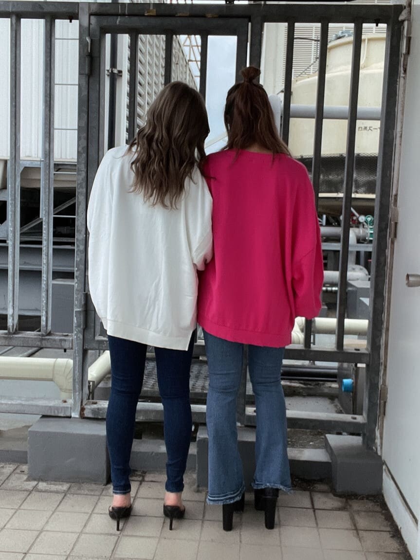 ブルー系のデニムパンツ、ホワイト系のスウェット、ピンク系のスウェットを着用したレディースの秋コーディネートの3枚目の写真