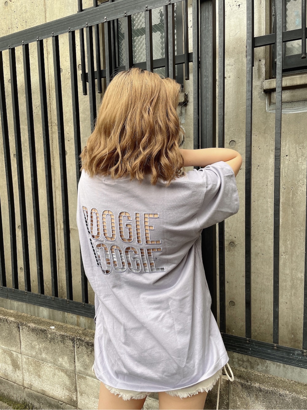 ホワイト系のチューブトップ、ホワイト系のデニムパンツ、パープル系のTシャツ/カットソーを着用したレディースの春コーディネートの3枚目の写真