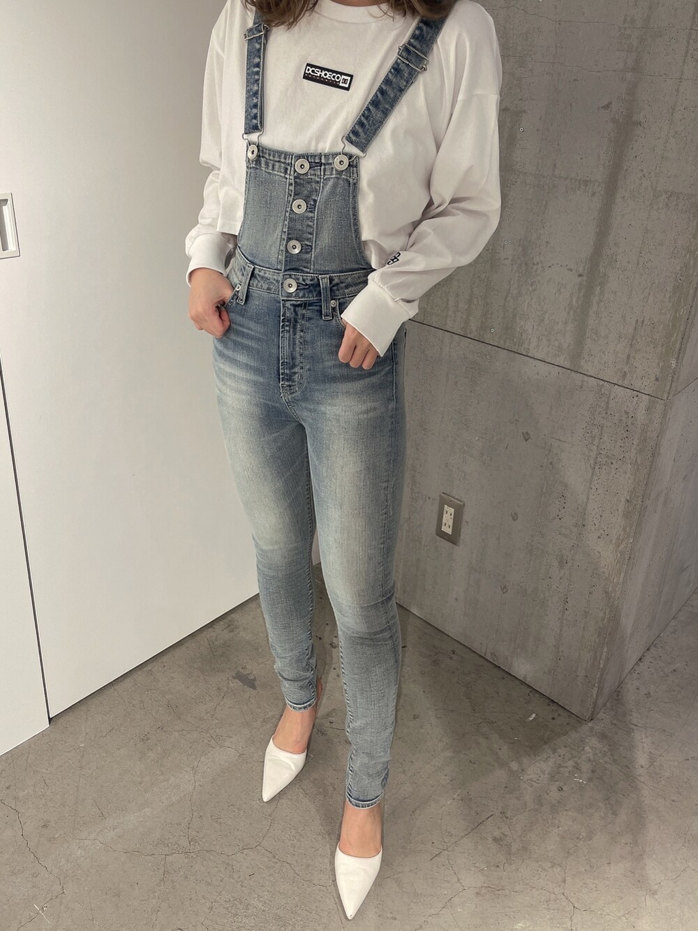 ホワイト系のTシャツ/カットソー、ブルー系のサロペット/オーバーオール、ホワイト系のパンプスを着用したレディースの冬コーディネートの8枚目の写真