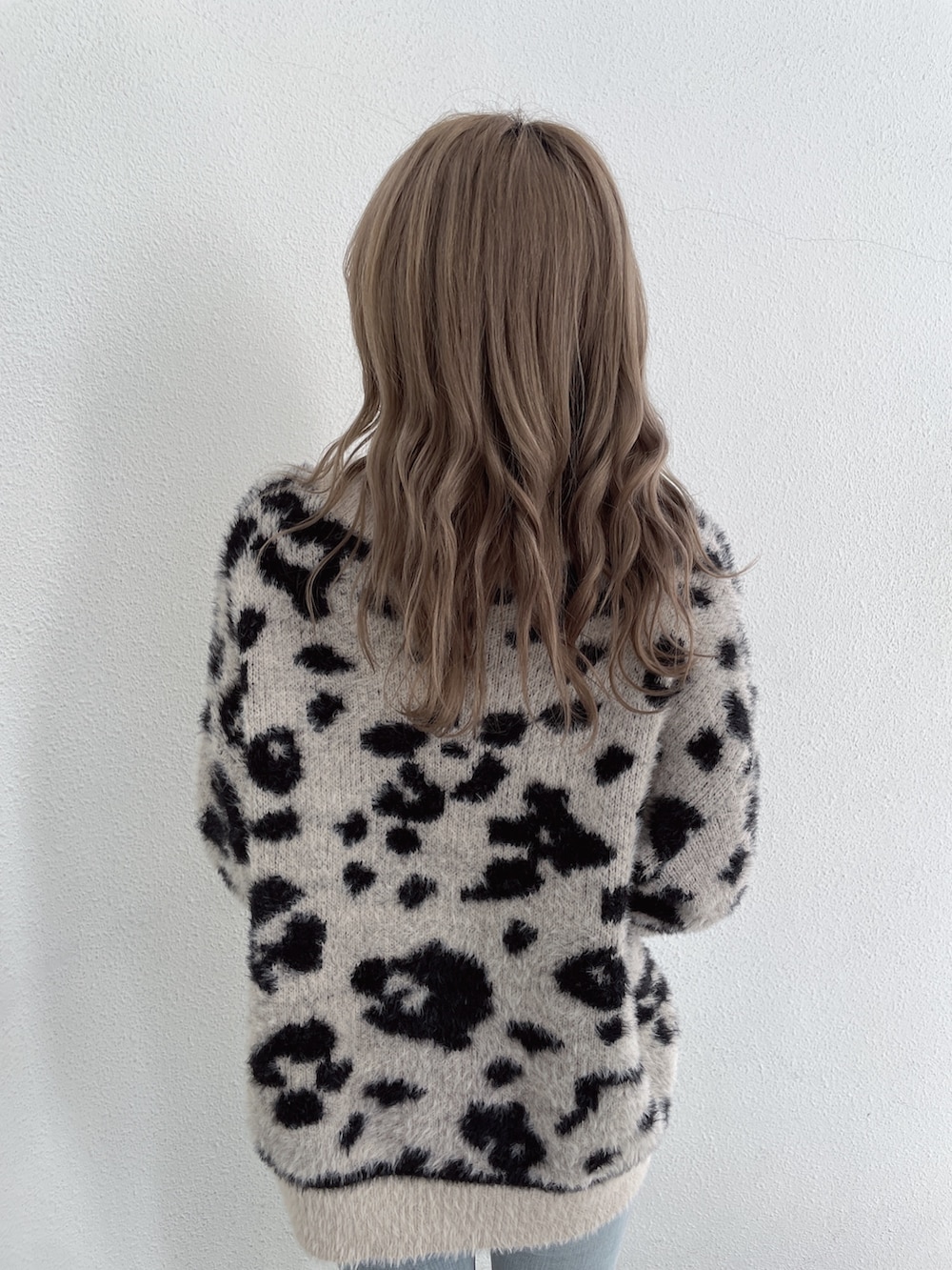 ベージュ系のニット/セーター、ブルー系のデニムパンツ、ホワイト系のパンプスを着用したレディースの冬コーディネートの4枚目の写真