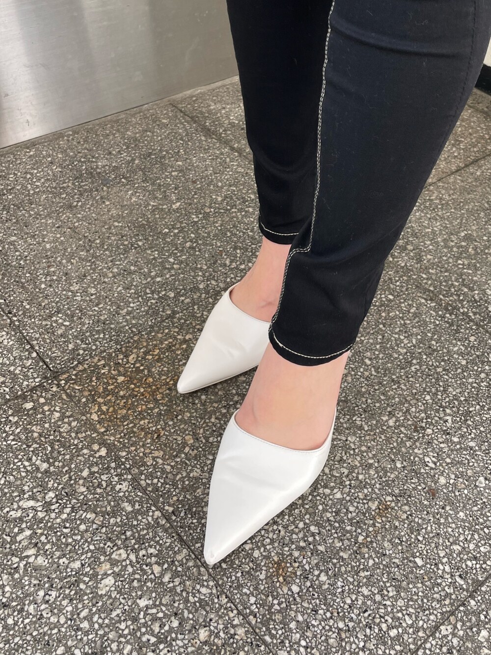 グレー系のニット/セーター、ブラック系のデニムパンツ、ホワイト系のパンプスを着用したレディースの冬コーディネートの7枚目の写真